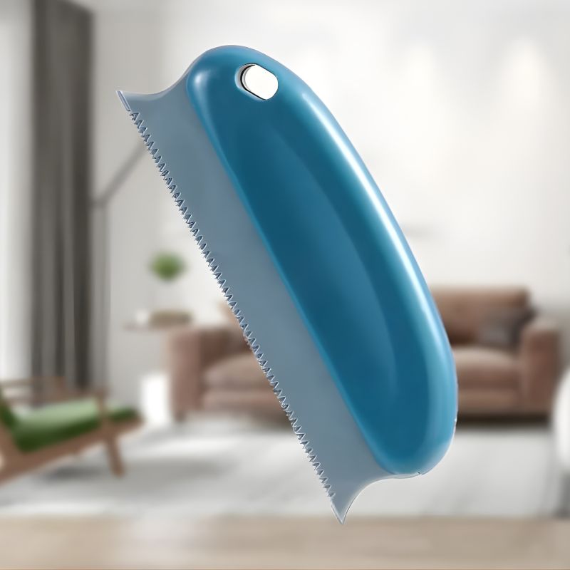 Blue pet grooming brush with a blurred indoor background
