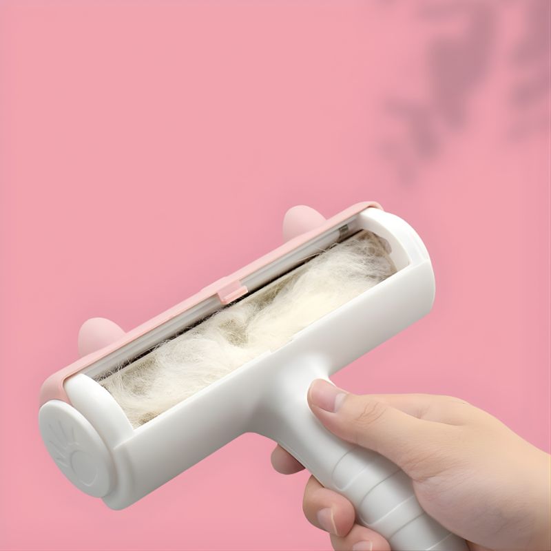 Hand holding a pet hair removal roller against a pink background