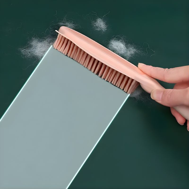 Person using a brush to remove dust from a surface with a green background
